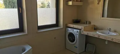 a bathroom with a washing machine and a sink at Dom Gościnny Zawoja in Zawoja