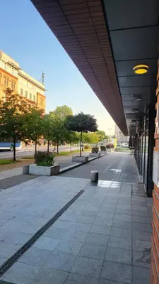 an empty sidewalk in a city with a building at AMBER APARTAMENt 108 in Kraków