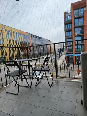 a table and chairs on a balcony with a building at AMBER APARTAMENt 108 in Kraków