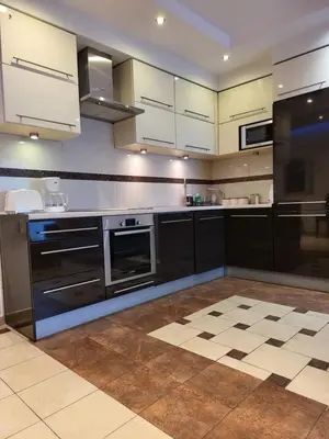 a kitchen with black appliances and white cabinets at AMBER APARTAMENt 108 in Kraków