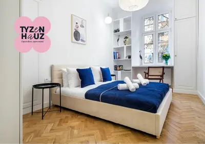 a living room with a blue couch and chairs at Tyzenhauz Apartments Krowoderska Street in Kraków
