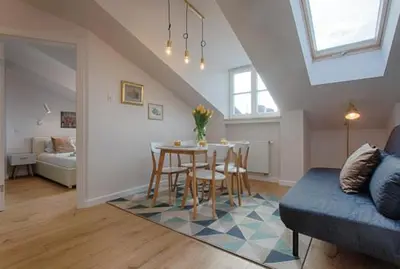 a living room with a table and a couch at Tyzenhauz Apartments Dietla Street in Kraków