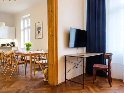a kitchen and dining room with a table with a television at Central Apartments by Tyzenhauz in Kraków