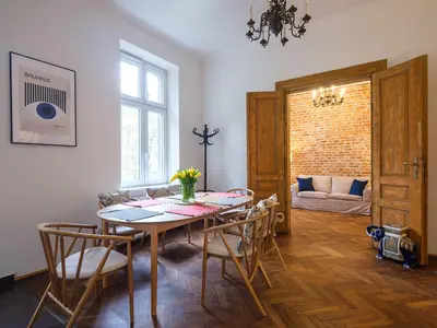 a dining room with a table and chairs and a couch at Central Apartments by Tyzenhauz in Kraków