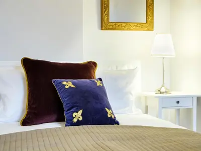 a bed with a blue pillow and a mirror at Central Apartments by Tyzenhauz in Kraków