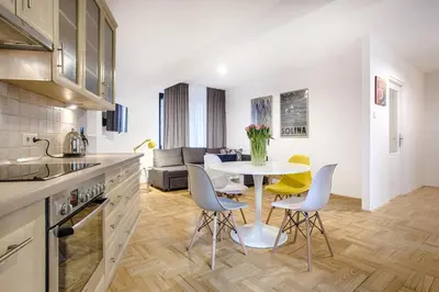 a kitchen and living room with a table and chairs at Central Apartments by Tyzenhauz in Kraków