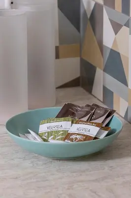 a blue bowl filled with packets of chocolate on a table at Mondrian Cracow - 2 Bedroom Apartment for Home Office by Noclegi Renters in Kraków