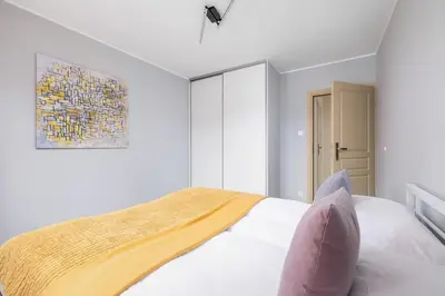a bedroom with a bed and a painting on the wall at Mondrian Cracow - 2 Bedroom Apartment for Home Office by Noclegi Renters in Kraków