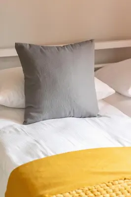 a white bed with a yellow pillow on it at Mondrian Cracow - 2 Bedroom Apartment for Home Office by Noclegi Renters in Kraków