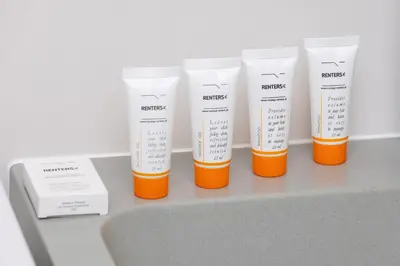 a group of four bottles of sunscreen sitting on a counter at Mondrian Cracow - 2 Bedroom Apartment for Home Office by Noclegi Renters in Kraków