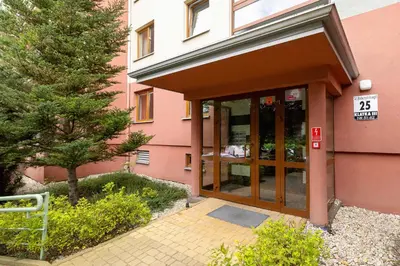 an entrance to a pink building with a sign on it at Mondrian Cracow - 2 Bedroom Apartment for Home Office by Noclegi Renters in Kraków
