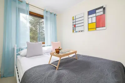 a small bedroom with a bed and a table at Mondrian Cracow - 2 Bedroom Apartment for Home Office by Noclegi Renters in Kraków