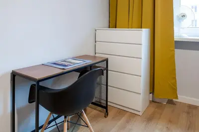 a desk with a chair next to a drawer at Nowa Huta Super Star in Kraków