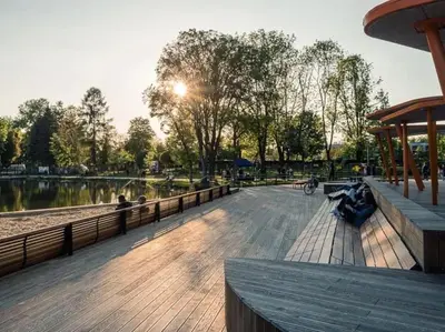 a group of people sitting on a boardwalk in a park at Nowa Huta Super Star in Kraków