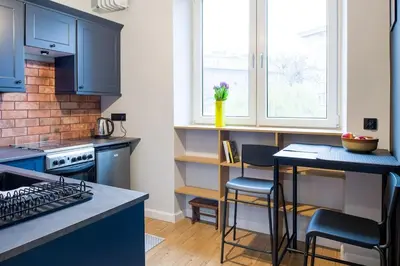 a kitchen with blue cabinets and a counter top at Nowa Huta Super Star in Kraków