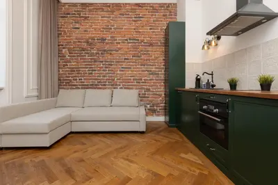 a living room with a couch and a brick wall at Apartment Strzelecka Old Town Cracow by Renters Prestige in Kraków