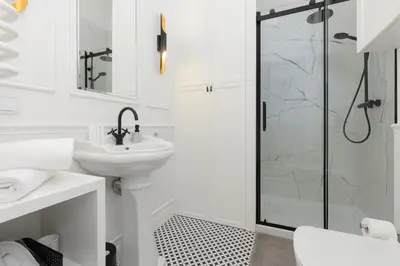 a white bathroom with a shower and a sink at Apartment Strzelecka Old Town Cracow by Renters Prestige in Kraków