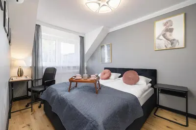 a bedroom with a bed with a table and a desk at The Historic Kazimierz District - Apartments with parking by Noclegi Renters in Kraków