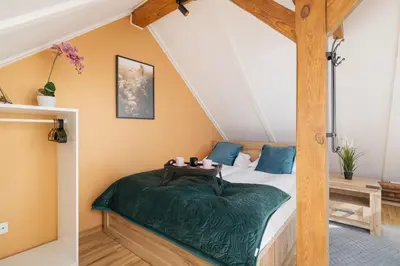 a bedroom with a bed with a green blanket at The Historic Kazimierz District - Apartments with parking by Noclegi Renters in Kraków