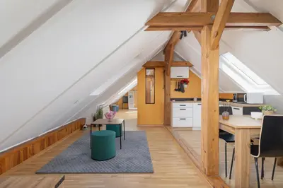 an attic kitchen and dining room with wooden beams at The Historic Kazimierz District - Apartments with parking by Noclegi Renters in Kraków
