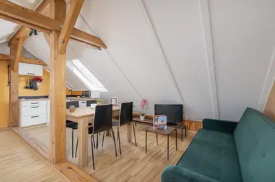 a living room with a green couch and a table at The Historic Kazimierz District - Apartments with parking by Noclegi Renters in Kraków