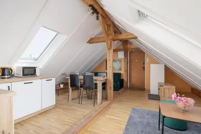 a kitchen and dining room in an attic at The Historic Kazimierz District - Apartments with parking by Noclegi Renters in Kraków