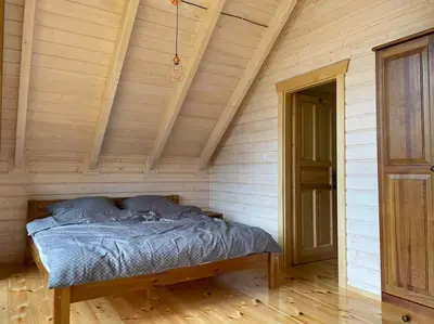 a bed in a room with a wooden ceiling at Blisko natury - chatki z sauną w Zawoi in Zawoja