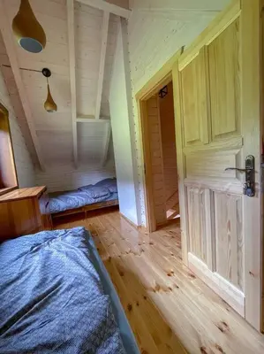 a bedroom with a bed and a wooden floor at Blisko natury - chatki z sauną w Zawoi in Zawoja