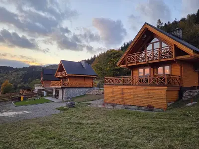 a log house with a balcony on the side of it at Blisko natury - chatki z sauną w Zawoi in Zawoja