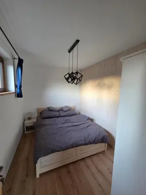 a bedroom with a bed and a chandelier at Blisko natury - chatki z sauną w Zawoi in Zawoja