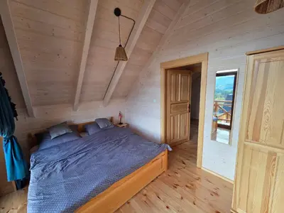 a bedroom with a bed in a wooden room at Blisko natury - chatki z sauną w Zawoi in Zawoja