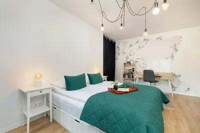 a bedroom with a large bed and a desk at Solna Cracow Air-conditioned Apartment with Balcony by Noclegi Renters in Kraków