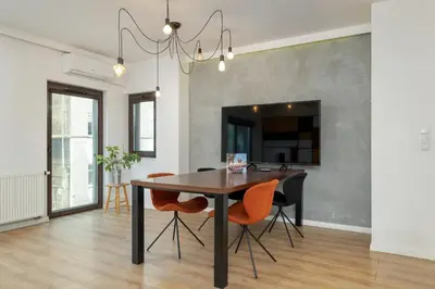 a dining room with a wooden table and orange chairs at Solna Cracow Air-conditioned Apartment with Balcony by Noclegi Renters in Kraków