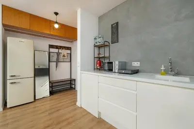 a kitchen with white cabinets and a refrigerator at Solna Cracow Air-conditioned Apartment with Balcony by Noclegi Renters in Kraków
