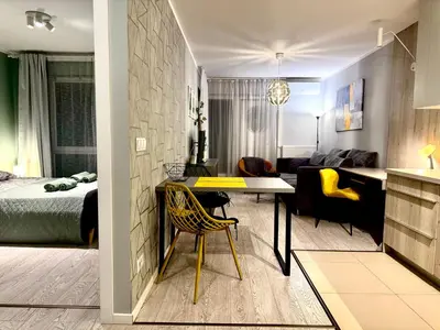 a room with a bed and a living room at Modern Apartament (10 min walk to Kazimierz) in Kraków
