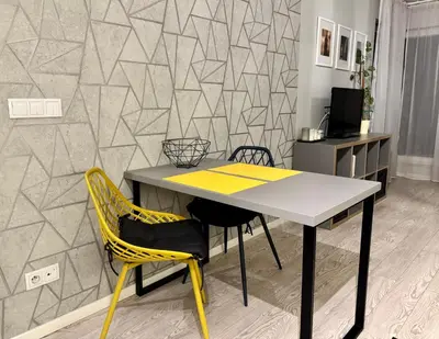 a table and chairs in a room with a wall at Modern Apartament (10 min walk to Kazimierz) in Kraków