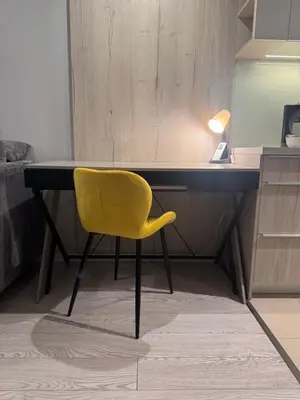 a yellow chair sitting in front of a desk at Modern Apartament (10 min walk to Kazimierz) in Kraków