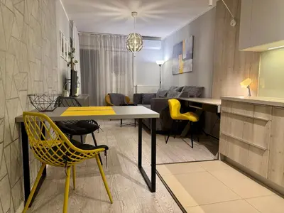 a kitchen and living room with a yellow table and chairs at Modern Apartament (10 min walk to Kazimierz) in Kraków