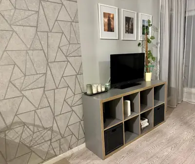 a living room with a flat screen tv on a cabinet at Modern Apartament (10 min walk to Kazimierz) in Kraków