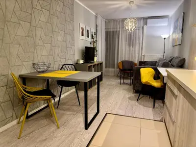 a kitchen and living room with a table and chairs at Modern Apartament (10 min walk to Kazimierz) in Kraków