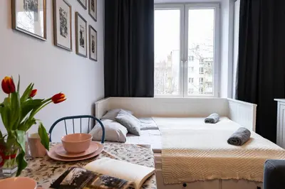 a bedroom with a bed and a table and a window at Cozy Old Town Studio in Kraków
