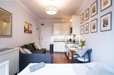 a living room with a couch and a table in a room at Cozy Old Town Studio in Kraków