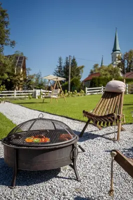 a grill and a bench next to a playground at Staymoovers - ManiaLand Domki pod Krakowem in Paszkówka