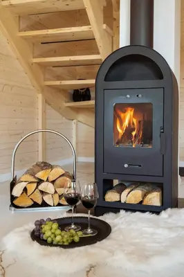 a fireplace with two glasses of wine and bread at Staymoovers - ManiaLand Domki pod Krakowem in Paszkówka