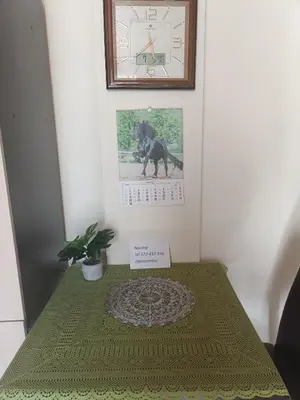 a table with a green table cloth and a picture of a dog at Domek Muchorek 1km od Energylandii in Zator