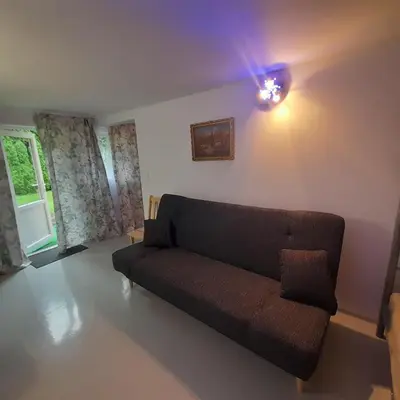 a living room with a couch and a light at Domek Muchorek 1km od Energylandii in Zator