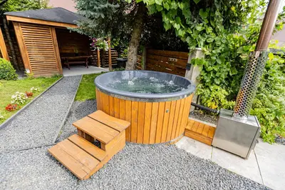 a hot tub in a garden with a bench at Dom w górach z kominkiem i balią ogrodową Sielanka in Skomielna Czarna