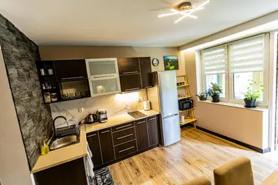 a kitchen with brown cabinets and a refrigerator at Dom w górach z kominkiem i balią ogrodową Sielanka in Skomielna Czarna