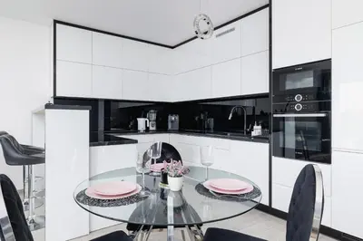 a kitchen with a glass table and black and white cabinets at Cracow Prądnik Spacious & Family Apartment with 3 bedroom by Renters Prestige in Kraków