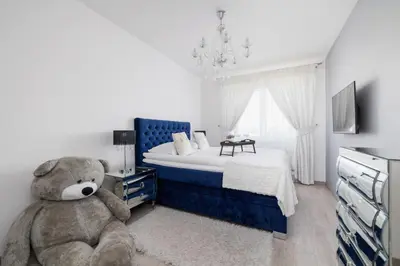 a teddy bear sitting in a bedroom with a bed at Cracow Prądnik Spacious & Family Apartment with 3 bedroom by Renters Prestige in Kraków